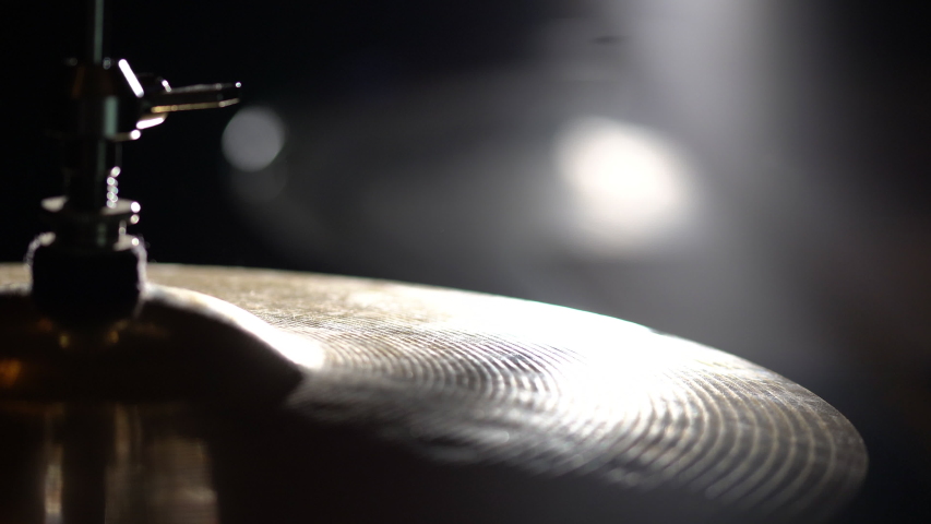 Playing hi-hat musical instrument. Hands of musician drummer holding drum sticks hitting on crash cymbal on dark background, closeup view. Drum cymbal vibration Royalty-Free Stock Footage #1046627749