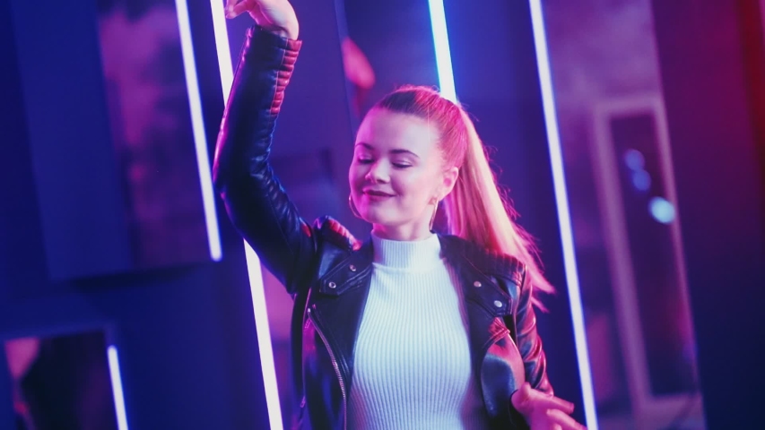 Neon girl. Night party. Happy young woman enjoying dancing in confetti rain purple illumination.