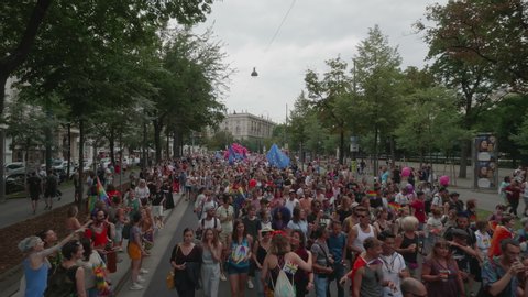 VIENNA AUSTRIA June 16 2018 – LBGT rainbow parade, gay pride parade, Regenbogenparade at the Ringstrasse Wien, wide moving shot of people following behind a party truck with music on the street, sound