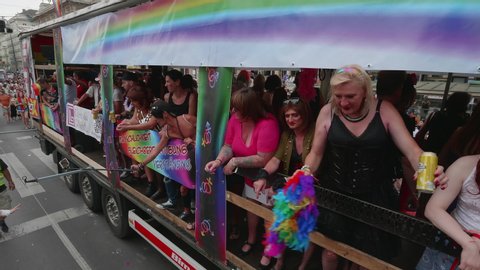 VIENNA AUSTRIA June 16 2018 LBGT rainbow parade gay pride parade Regenbogenparade at the Ringstrasse Wien, moving shot of a guy on a truck in a dress waving his colorful scarf at the parade with sound