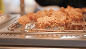 cook takes tongs chicken nuggets from counter