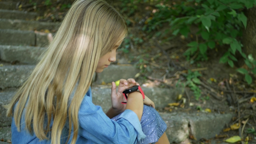 Smart Watch, Kid Using Smartwatch, Child Talking at Smartphone, Teenager Girl Browsing Internet Outdoor in Park
