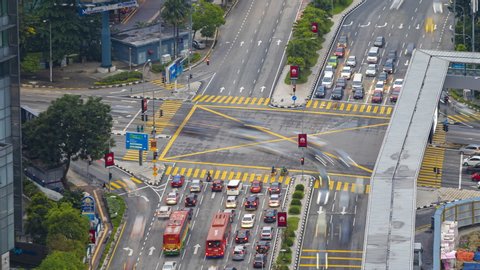 KUALA LUMPUR, MALAYSIA  - NOVEMBER 02, 2019 : Time lapse : High angle late afternoon shot of a busy city traffic light intersection with cars light trails in Malaysia. Zoom out motion timelapse.