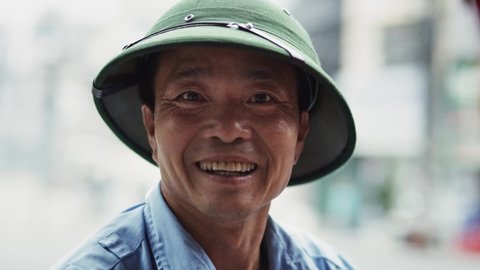 Handheld video shows of Vietnamese mature man looking at camera.  