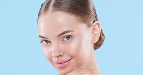 Beauty woman face isolated on blue background. Skin care. Beautiful female model with perfect clean fresh skin