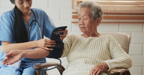 Nurse measure blood pressure for asian woman carefully. Health care and Medical concept.