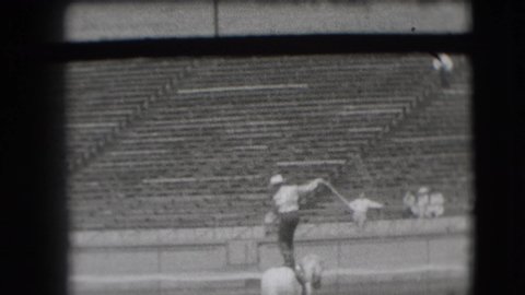 DENVER COLORADO USA-1941: Cowboy In Arena Standing On Horse Grabs Other Horse With Lasso Black And White