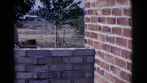 COTTONWOOD ARIZONA-1968: Man Stands Outside In The Sun Building A Brick Wall