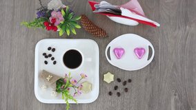 Top view spinning video of coffee cup with candies and flowers bouquets. FHD.