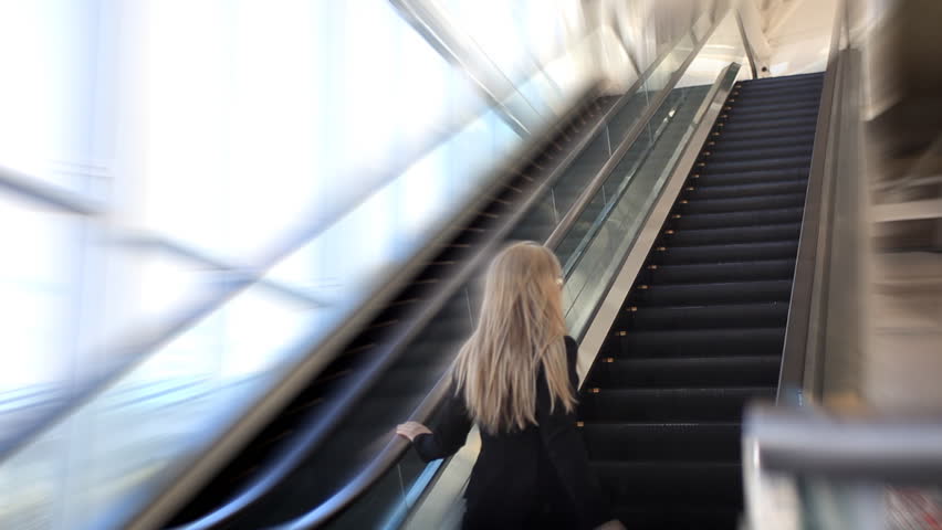 woman taking the escalator
