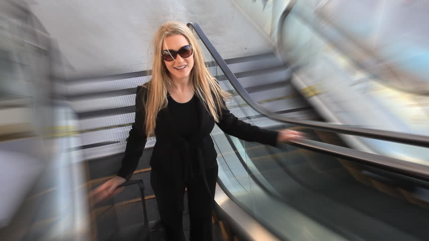 happy woman taking the escalator