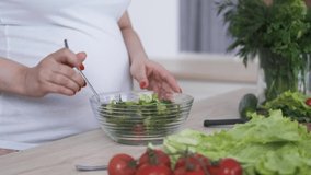 Healthy diet pregnant woman cook salad with fresh vegetables and herbs close-up