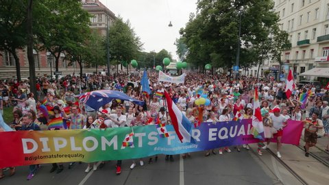 VIENNA AUSTRIA June 16 2018 – LBGT rainbow parade, gay pride parade, Regenbogenparade at the Ringstrasse Wien, a group of colorful people holding a banner waving flags marching the street, with sound