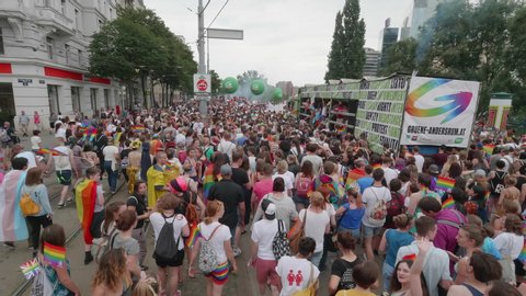 VIENNA AUSTRIA June 16 2018 – LBGT rainbow parade, gay pride parade, Regenbogenparade at the Ringstrasse Wien, wide moving shot of people following a party truck with music on the street, sound