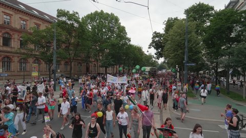 VIENNA AUSTRIA June 16 2018 – LBGT rainbow parade, gay pride parade, Regenbogenparade at the Ringstrasse Wien, wide shot a group of people holding a banner waving flags marching the street, with sound