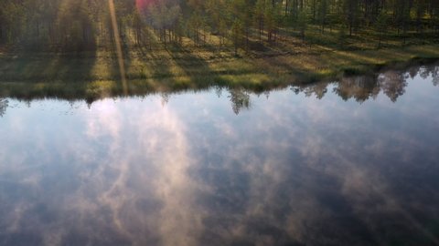 Fog drifting over mirror calm pond of a boreal forest in Finland
