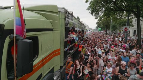 VIENNA AUSTRIA June 16 2018 LBGT rainbow parade gay pride parade, Regenbogenparade at the Ringstrasse Wien, moving Segway shot of a large crowd dancing on the street next to a party truck, with sound