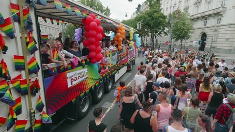 VIENNA AUSTRIA June 16 2018 LBGT rainbow parade gay pride parade Regenbogenparade at the Ringstrasse Wien, moving shot of girls on a party truck waving, people at the parade following them, with sound