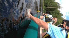 Senior couple canoeing on a forest lake in Finland. Active retirees enjoy outdoor sports. Sportive elderly people having fun at the nature. A vertically-oriented video.