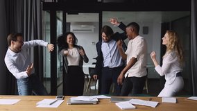 Happy multiracial colleagues dancing in office throwing papers in air celebrating corporate success. Excited multiracial different generations motivated teammates enjoying victory dance at workplace. - Powered by Shutterstock - Get 15% off with code: PIKWIZARD15