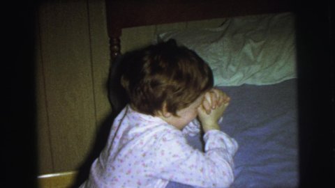LYNBROOK NEW YORK USA-1976: Child Praying Before Going To Bed And Two Other Children Getting Ready For Bed