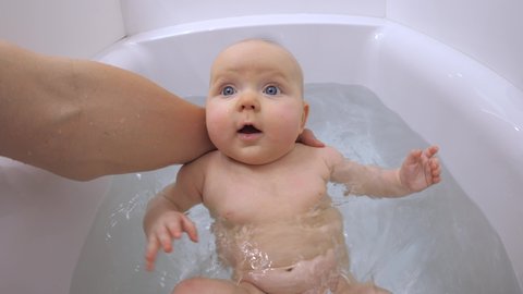 Father Bathing Little Baby In Bathtub. 