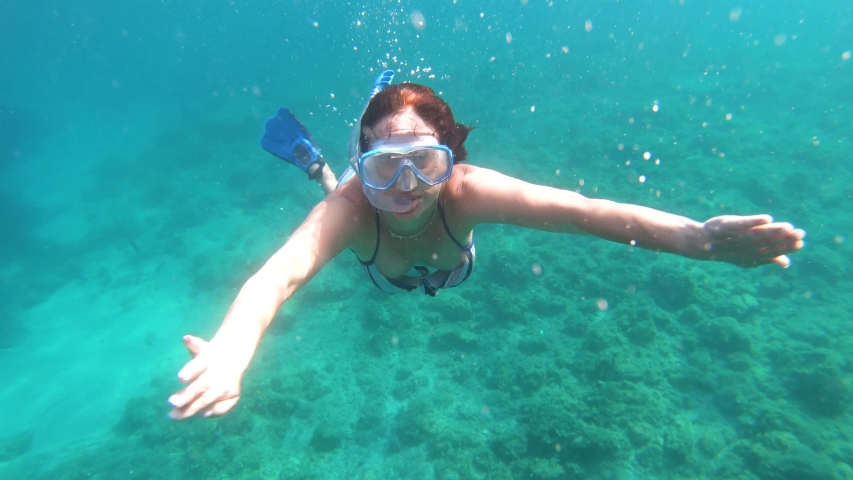 Underwater view of girl in bikini snorkeling in crystal clear sea water | Shutterstock HD Video #1046808667