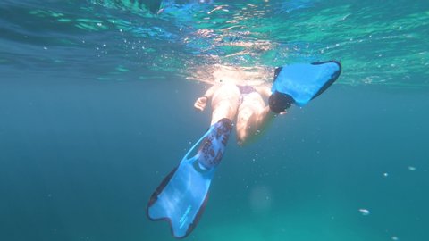 Underwater view of sexy girl in bikini snorkeling in tropical sea water