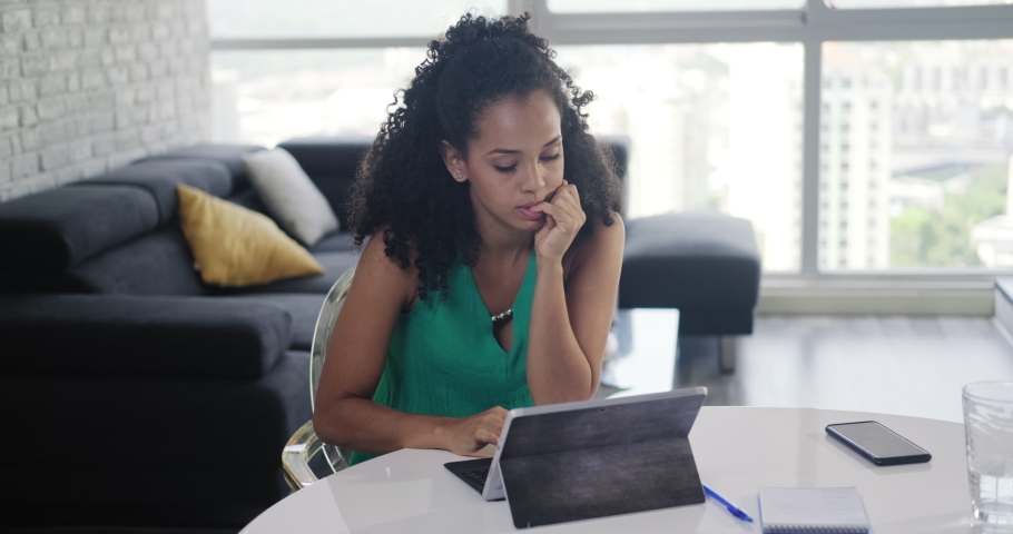 Young black business woman working with laptop computer at home. Anxious girl studying with pc. Nervous African American people and technology Royalty-Free Stock Footage #1046818249
