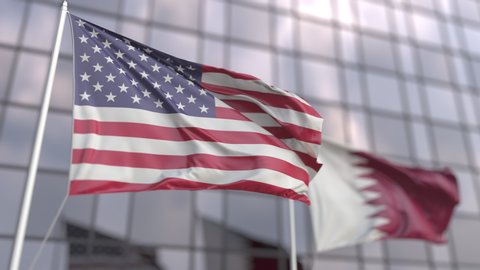 Waving flags of the United States and Qatar in front of a skyscraper facade