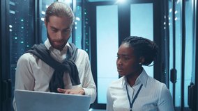 Couple of IT admins laughing together inside working server cabinet. Stressed man makes a mistake and negatively surprises his colleague. - Powered by Shutterstock - Get 15% off with code: PIKWIZARD15