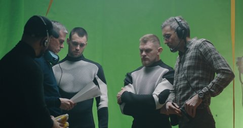 Medium shot of a director giving instructions to crew members before shooting a film scene