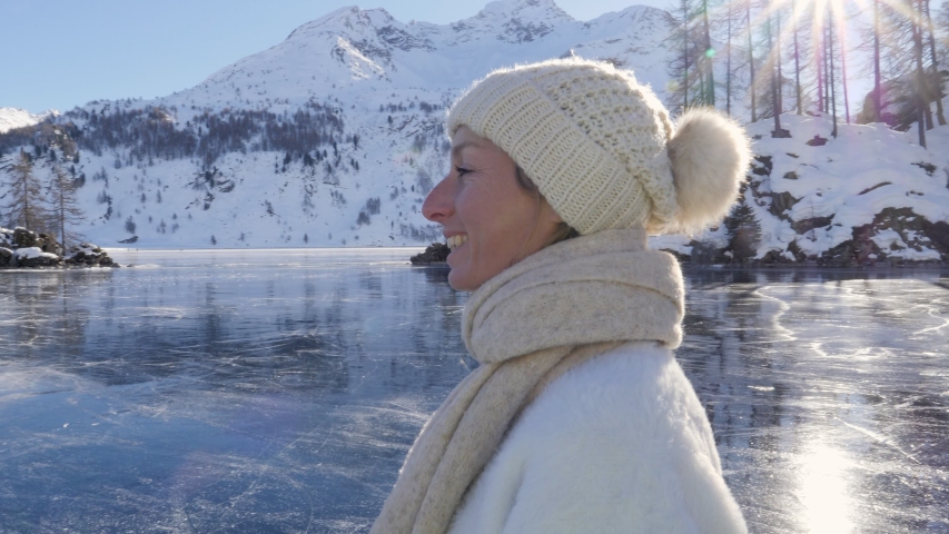 Closed up, woman on ice skates having fun of frozen Alpine lake in winter 