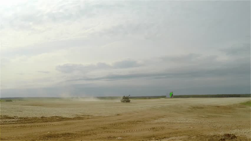 Howitzer on tracks move at the military training ground in the dust