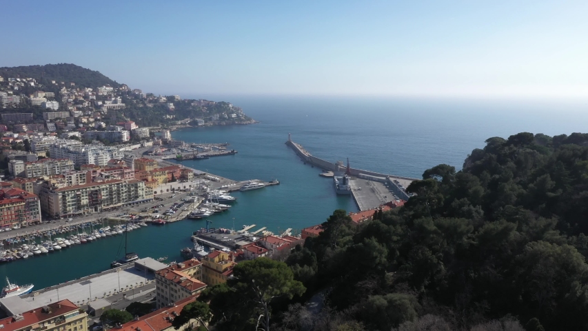 Nice, France. Drone flying over the city buildings, graveyard and green park to the harbour with yachts