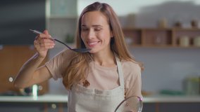 Pretty woman cooking soup on stove at kitchen. Close up of housewife preparing dinner at home. Young woman tasting soup on spoon at modern kitchen in slow motion - Powered by Shutterstock - Get 15% off with code: PIKWIZARD15