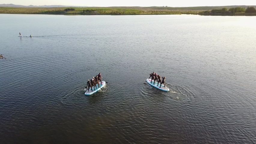 Sunset Aerial Shot Of A Group Of Sup Surfers Floating In Hafravatn Lake In Iceland