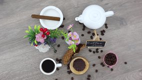 top view spinning video of coffee cup with marshmallow and white kettle with flowers and cigar in ashtray. FHD.