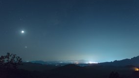 Time lapse in 4k video. The phenomenon of star arrangement (Saturn, Moon, Venus, Jupiter) in the misty night sky on a hill, long exposure, Mae Moh, Lampang, Thailand.