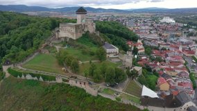 Circling video of above medieval restored Trencin castle and town on a cloudy day in Slovakia