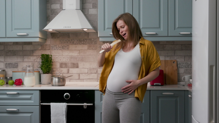 Joy and Fun Pregnant Mother Active Dancing in Home and Preparing Eat. Happy Emotions Young Mother. Cheerful Woman Enjoyable Sing Song. Concept of Family. Сarefree Lifestyle Joyful People Holiday 4k | Shutterstock HD Video #1046873539