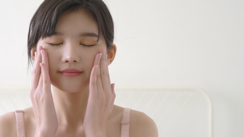 Beautiful young asian woman makeup of cosmetic for facial soft, girl hand touch face smooth applying cream and lotion for rejuvenation, beauty perfect with wellness, skin care and health concept.