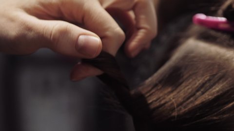 The stylist twists the girl's hair before coloring. Beautiful elegant movement of the stylist's hand. 4K slow motion. Close up