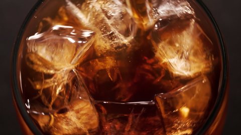 Ice cubes in Cola drink beverage Macro shot closeup Top view