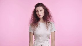 irritated woman showing dislike isolated on pink