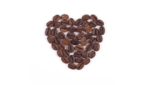 Stop Motion animation of coffee beans heart shape on white background made from coffee beans. Coffee lover and Valentine's Day concept. 4K Resolution Ultra HD. Video Stok