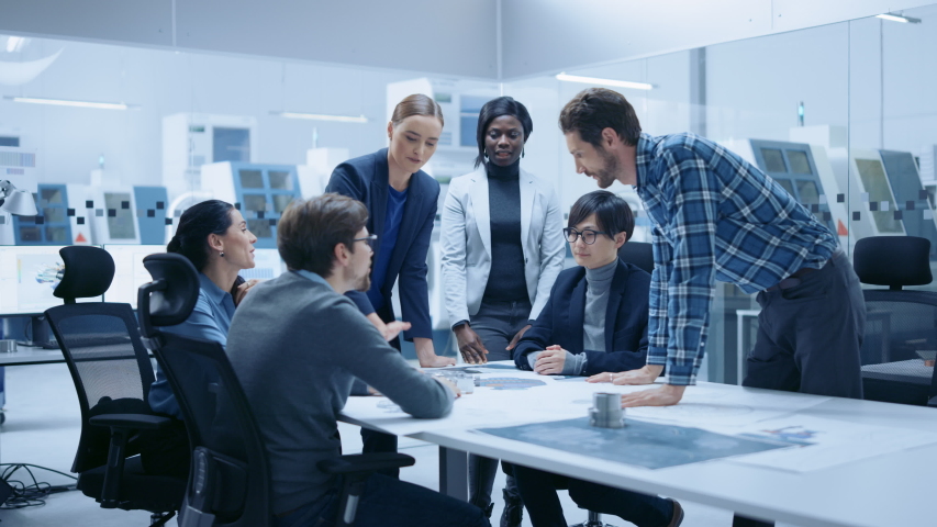 Multi Ethnic Team of Industrial Engineers Standing at the Conference Table Successfully Solve Project Problems, They're Happy and Celebrate with High Five and Cheers. Modern Factory. Slow Motion Royalty-Free Stock Footage #1046904619