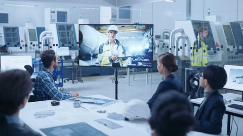 Diverse Group of Specialists, Managers in the Factory Office Meeting Room, Have Conference Video Call with Factory Chief Female Engineer, She Talks about Production Growth, Uses Tablet Computer