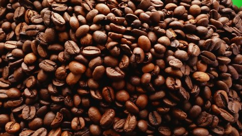 Coffee background on green screen.HQ coffee transition video. Falling coffee concept. Top view of freshly roasted coffee beans