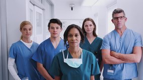 Portrait of multi-cultural medical team standing in hospital corridor - shot in slow motion - Powered by Shutterstock - Get 15% off with code: PIKWIZARD15